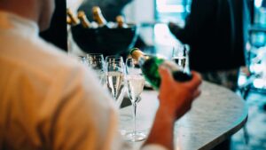 A photo of a waiter pouring champagne into glasses at an event