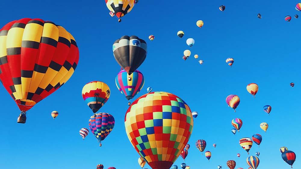 A photo of bright coloured hot air balloons on the sky
