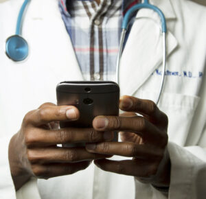 Medical personnel holding a mobile phone, using technology in healthcare