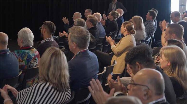 a crowd of people applauding at an event